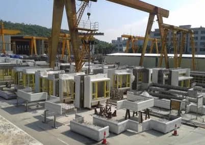 Finished light-colored precast concrete components stored in an outdoor factory yard