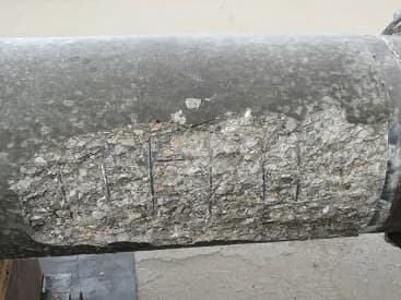 Concrete crushing and reinforcement exposure after a circular concrete pole load test