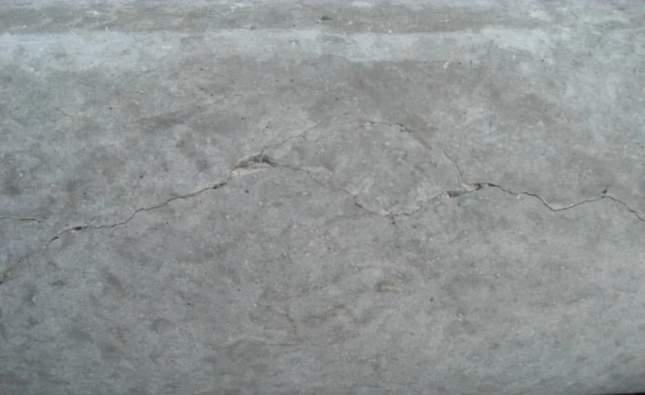 Close inspection view of surface cracking on a finished circular concrete utility pole